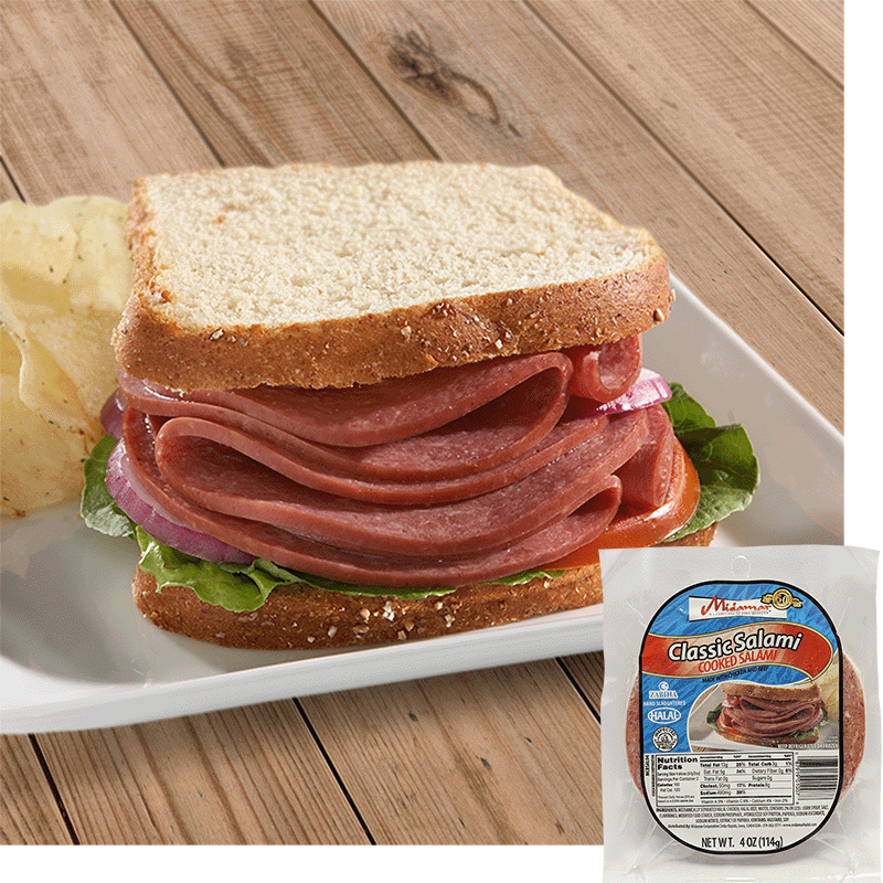 A Halal Beef salami sandwich with white bread red onion, tomato, and lettuce on a white plate with some potato chips behind to the left. A pack of Midamar Halal Classic Salami is overlayed in the bottom right corner. 